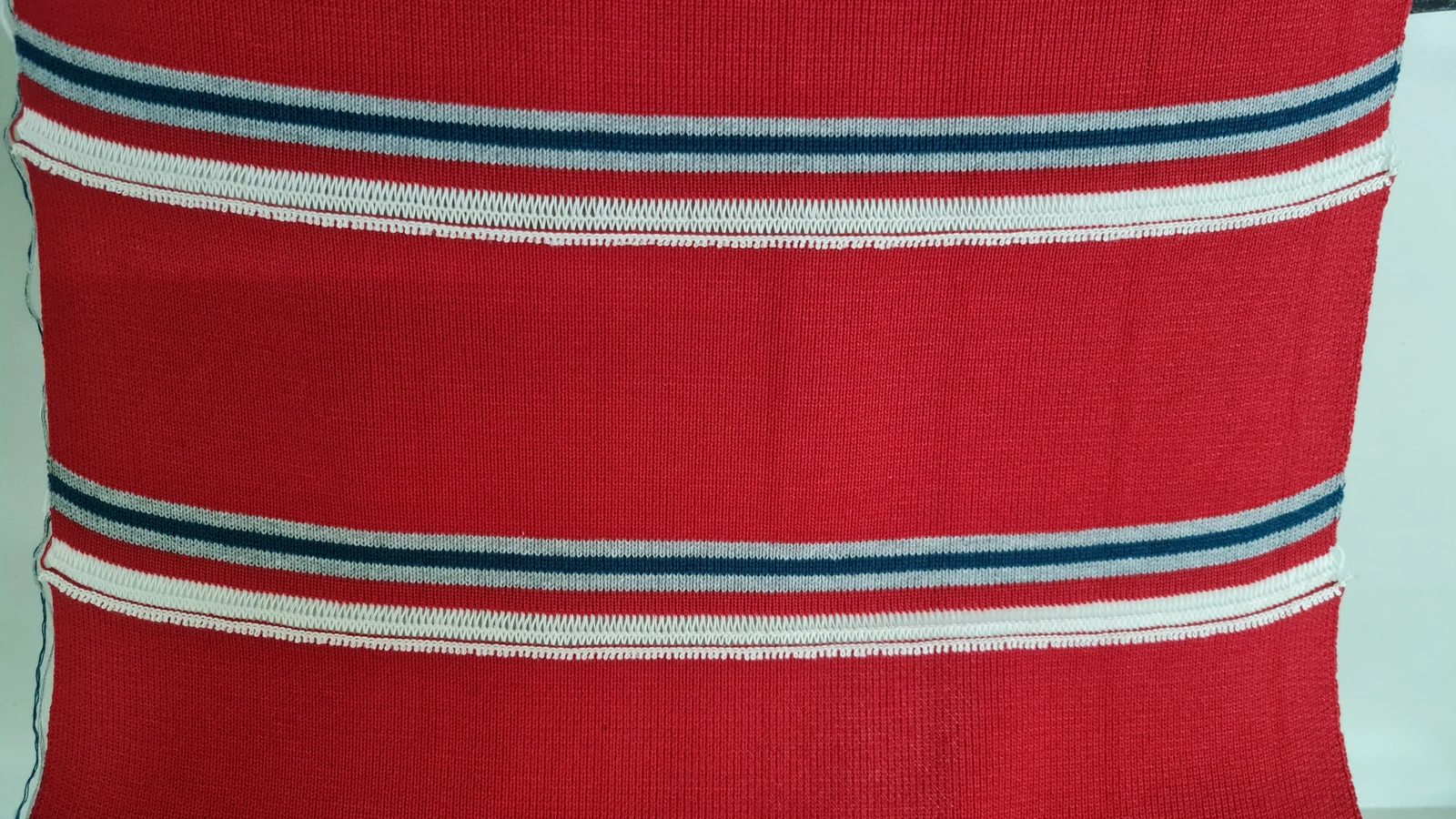 Tejido rojo con franjas grises y azul marino
